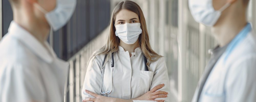 woman in white coat wearing white face mask