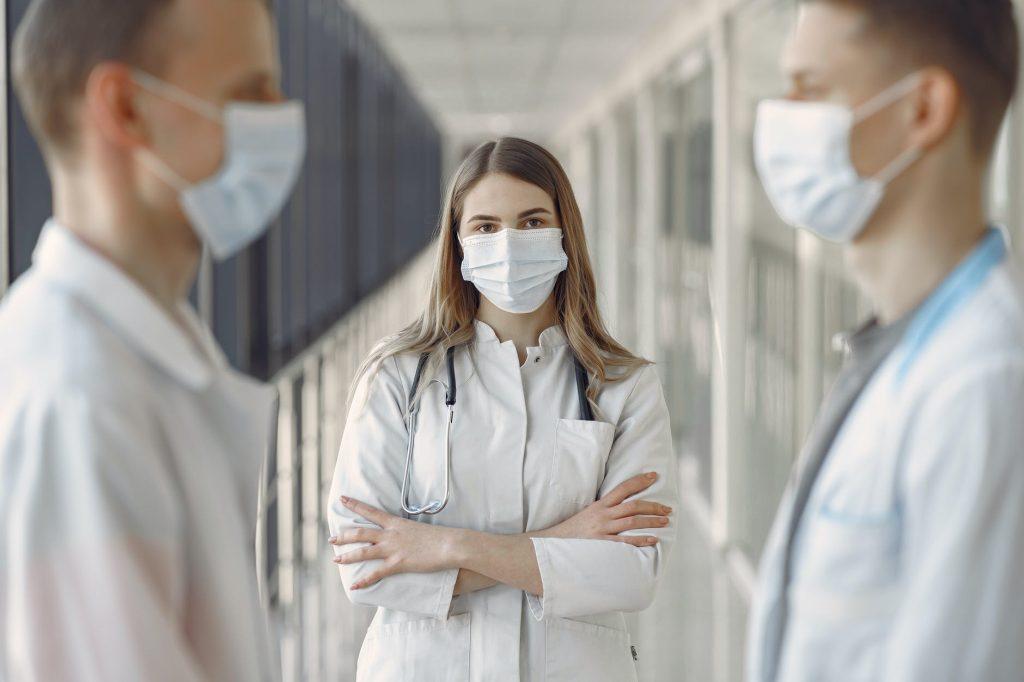 woman in white coat wearing white face mask