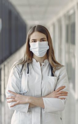 woman in white coat wearing white face mask